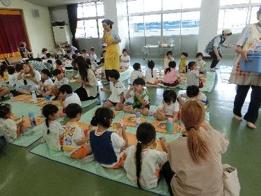 園児たちがグループで給食を食べている様子の写真