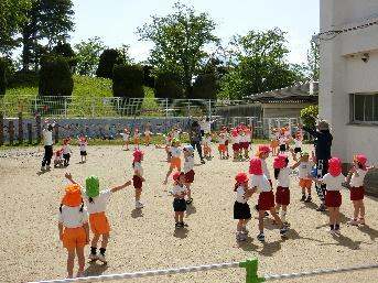 園児たちが外で友達と一緒に遊んでいる様子の写真