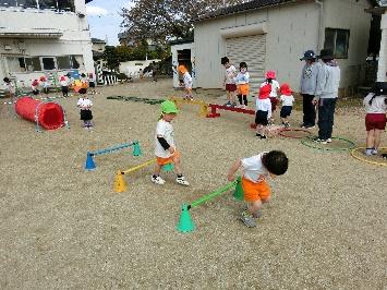 園児たちが外で遊具で遊んでいる様子の写真