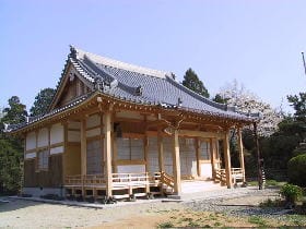 瓦屋根で木造の柱がたてられた本堂の外観写真