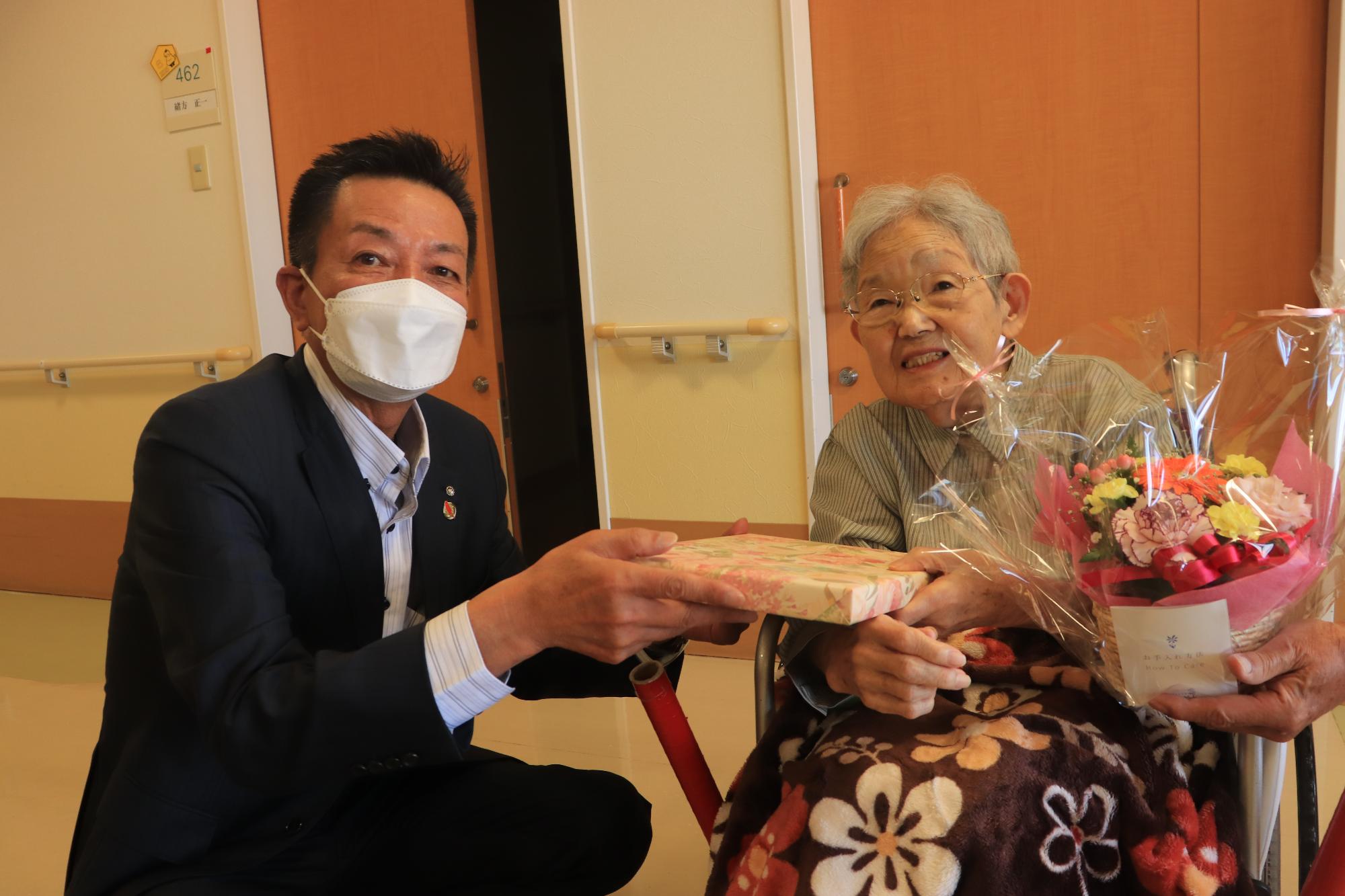 百寿のかたへ記念品を渡す阪本町長