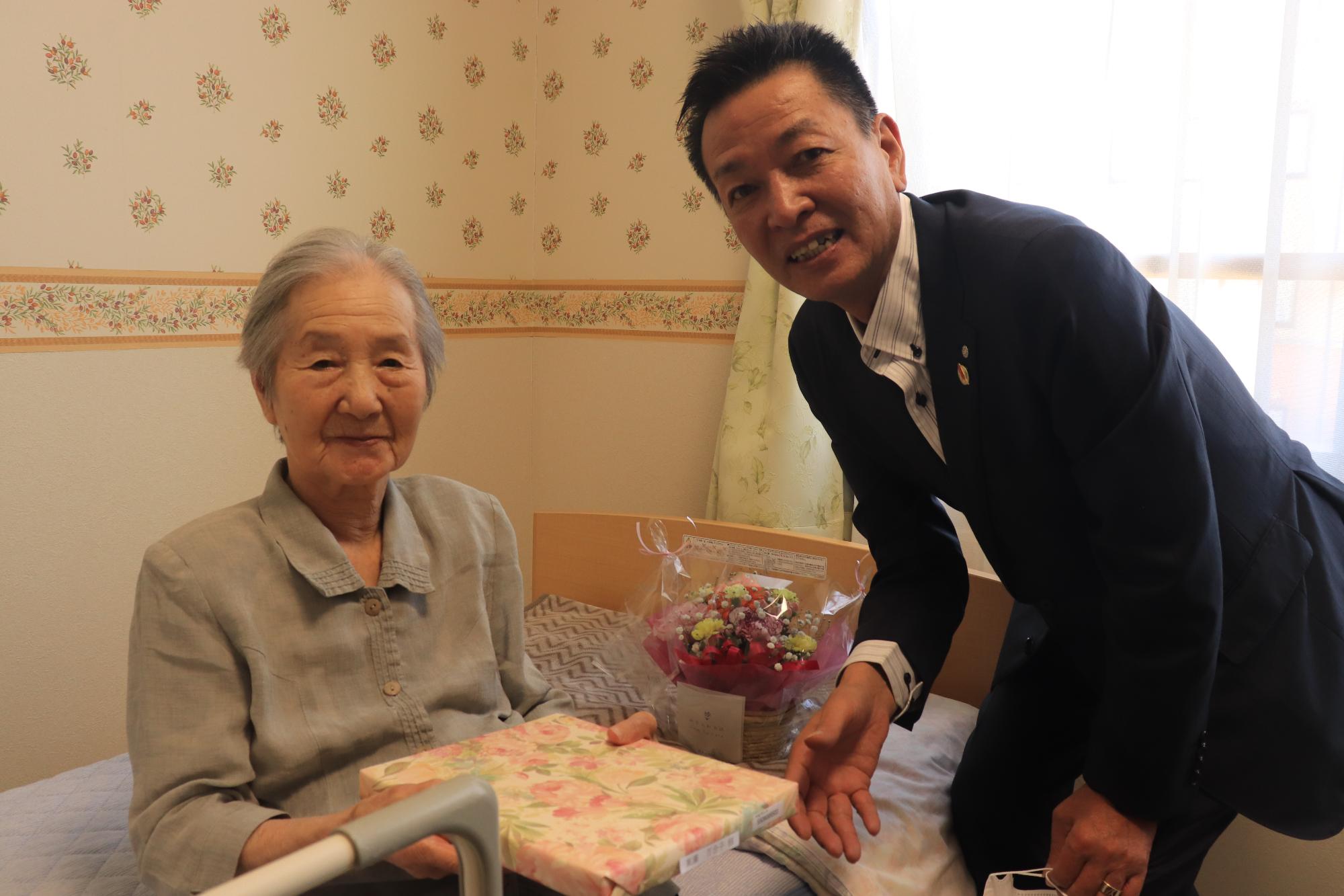 百寿のかたへ記念品を渡す阪本町長