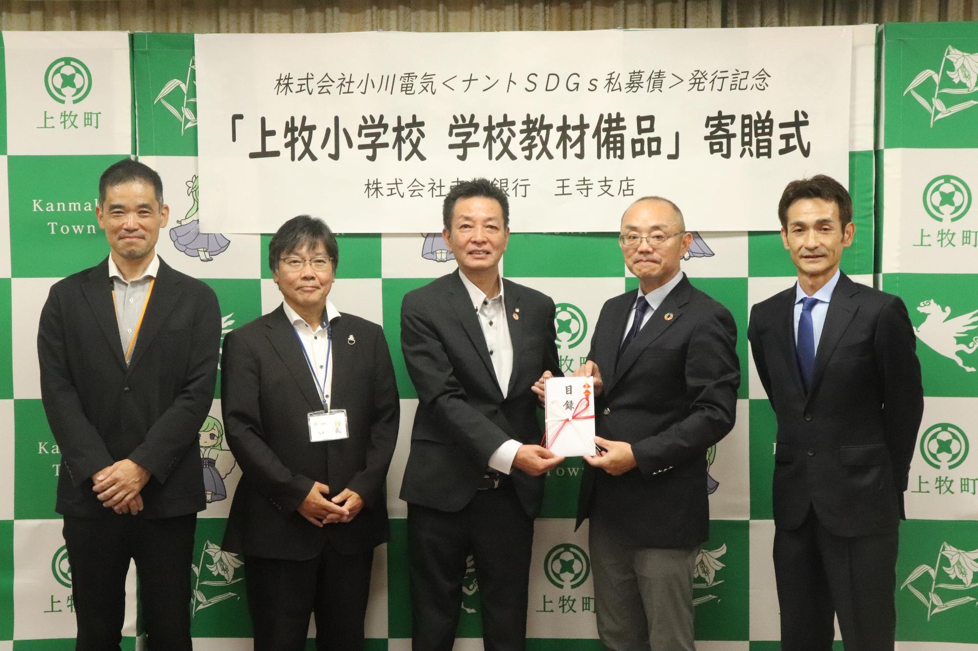 寄贈式で目録を受け取る阪本町長