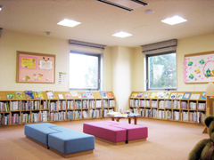 本棚が並び青と赤のソファが真ん中にある図書館の中の写真画像