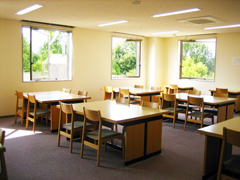4人ずつ利用できる机と椅子が配置されている自習室の写真画像