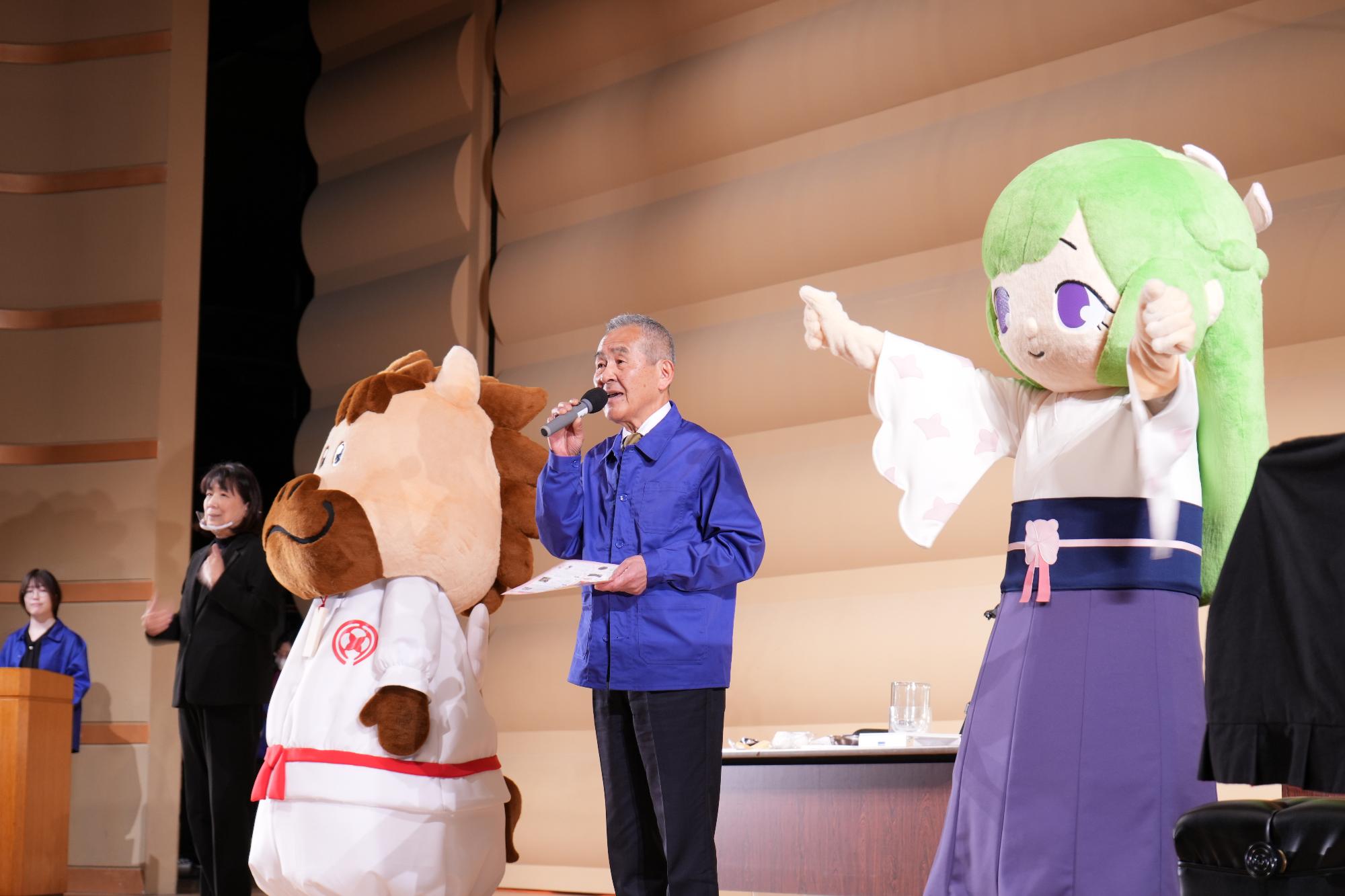 令和5年3月26日に開催した上牧町さくら祭りのオープニングでステージに立つ町長とゆりはちゃん、上牧ぺたろう