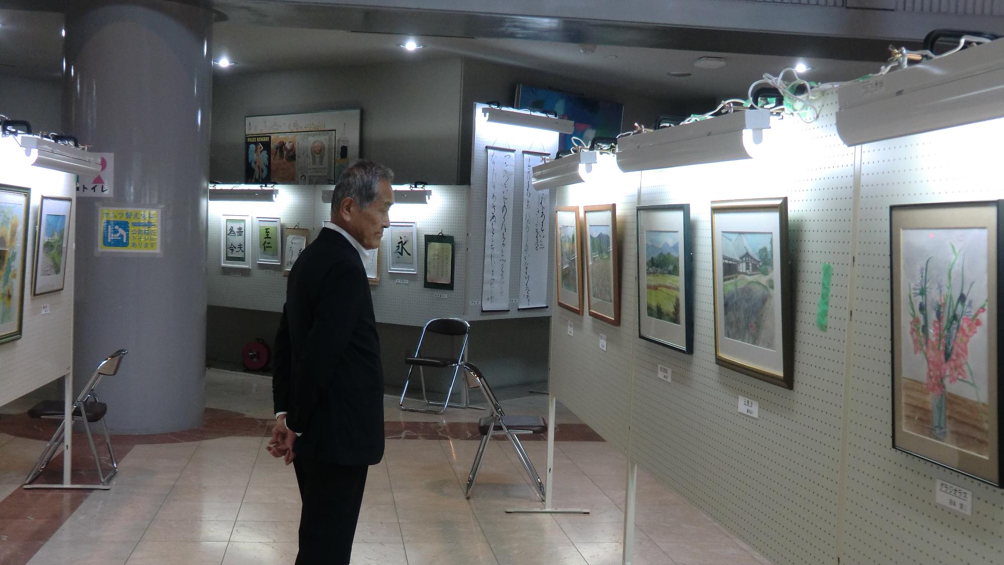 上牧町文化祭で展示された絵画を見つめる今中町長