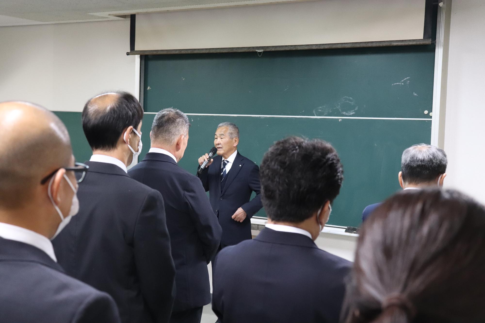 並んだ町職員の前で仕事始めの挨拶をする今中町長