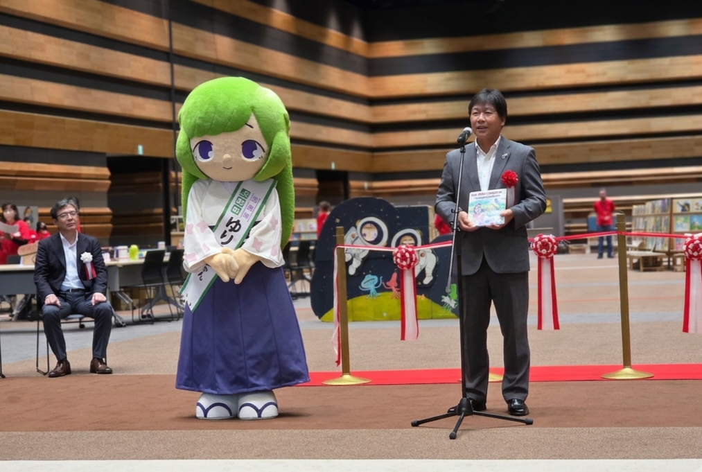 上牧町教育委員会教育長と絵本の紹介をするゆりはちゃん